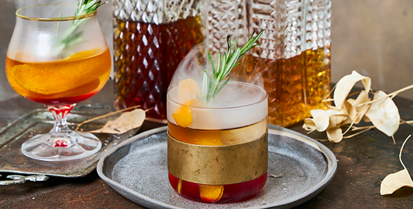 Lingonberry whiskey drink with rosemary and smoke